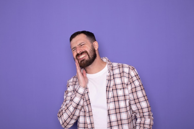 Man touching mouth with painful expression because of toothache or dental illness on teeth