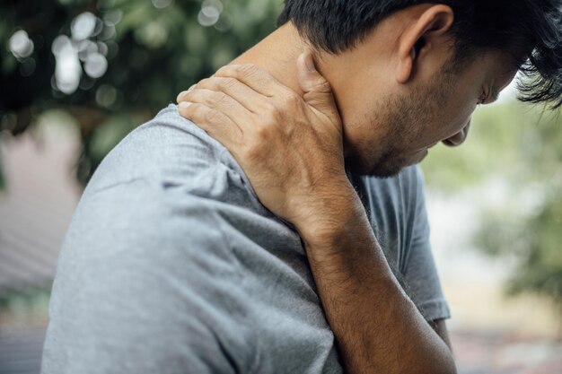 Man touching neck in pain