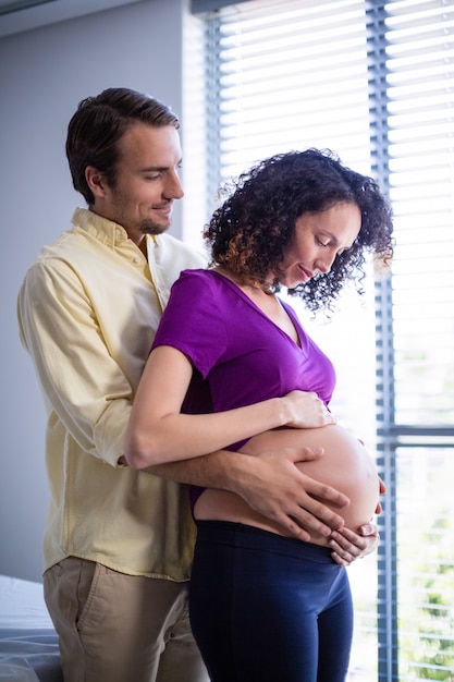 Pancia della donna incinta commovente dell'uomo in reparto