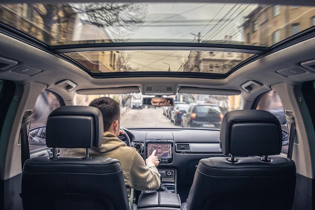 Человек, касающийся экрана навигационной системы GPS в своей машине