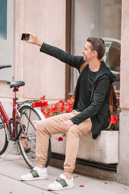 Man tourist in Europe street. Caucasian boy looking with map of European city.