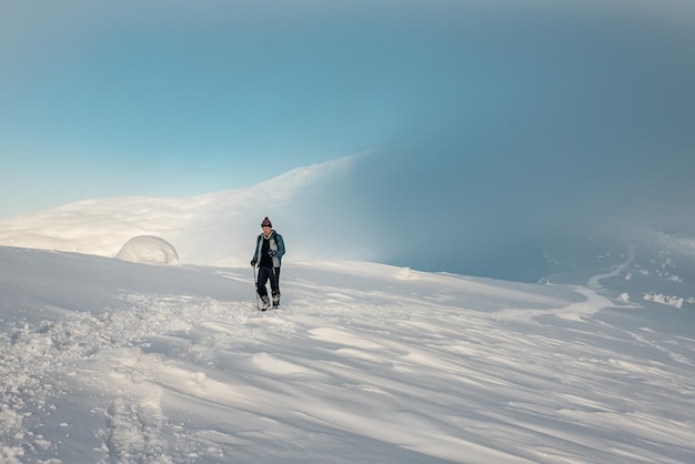 Man tourist hiking in winter Carpathian mountains