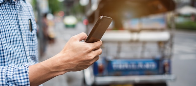 Foto taxi di ordinazione turistica dell'uomo tramite l'applicazione della cabina su smartphone