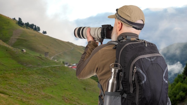 写真 バックパックを背負った男性の観光写真家が自然の美しさを撮影しています