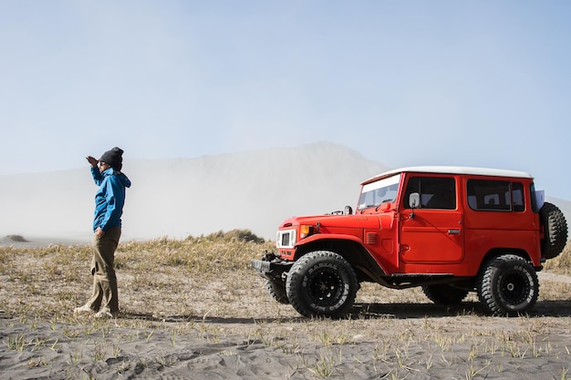 Man tourist on sand dune in desert during off road vehicle on sand savannah at Bromo Mountain Tengger East Java Indonesia on Aug 12 2017