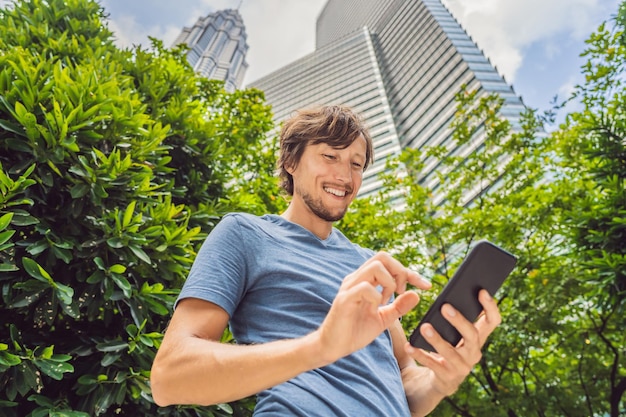 Man tourist using navigation app on the mobile phone navigation\
map on a smartphone in a big city