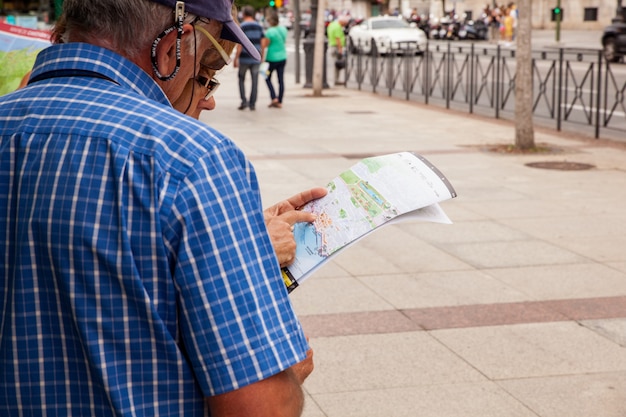 Photo man tourist with map on the street