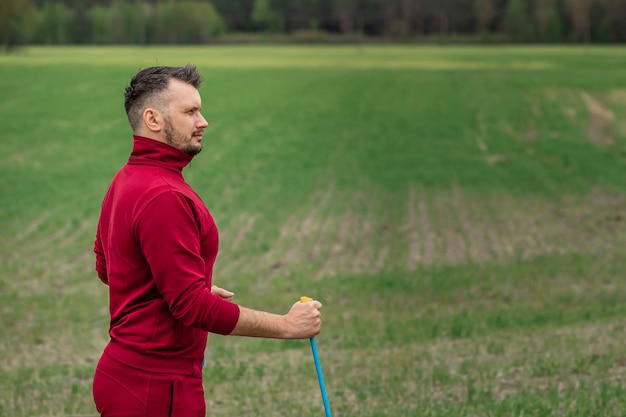 A man in a tracksuit is engaged in Nordic walking