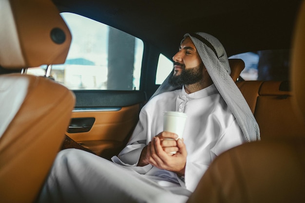 A man in a traditional arabian clothing in a car