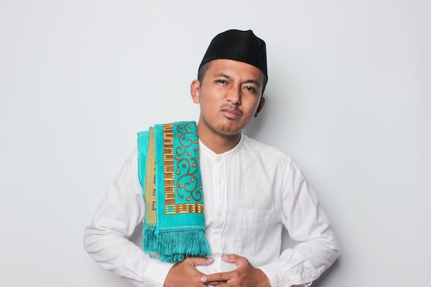 A man in a traditional malay outfit with a blue and green scarf.