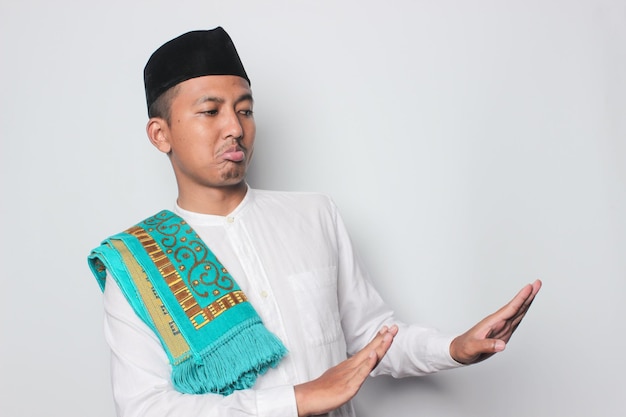 A man in a traditional outfit is holding a phone and wearing a blue and green scarf.