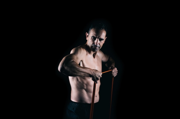 Man trainen met een elastiekje op een zwarte achtergrond