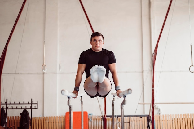 Photo man training on parallel bars