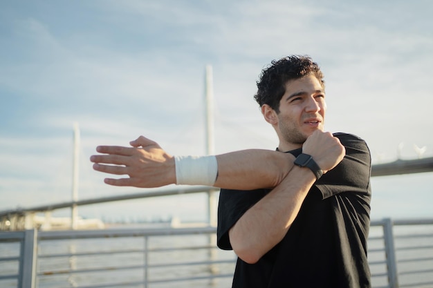 A man trains outside in sportswear Uses a fitness watch and a running app