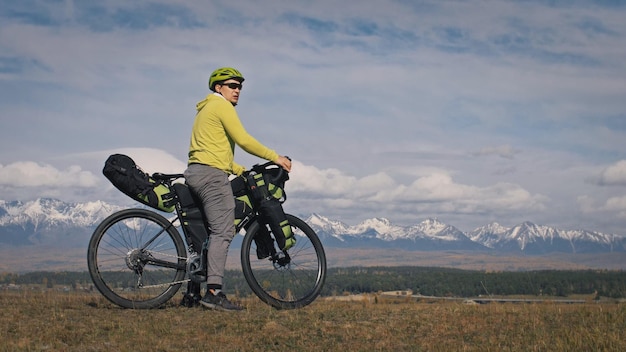 男はバイクパッキングでバイクパッキングで旅行します自転車バッグで旅行者の旅スポーツ観光バイクパッキング