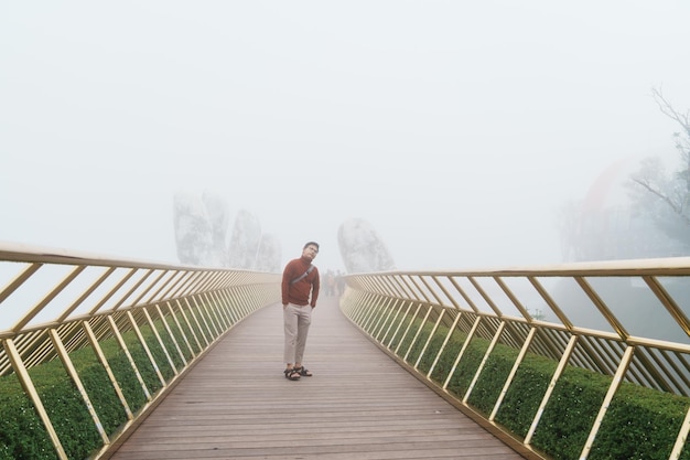 Man Traveler sightseeing Golden bridge at the top of the Ba Na Hills Landmark and popular Vietnam and Southeast Asia travel concept