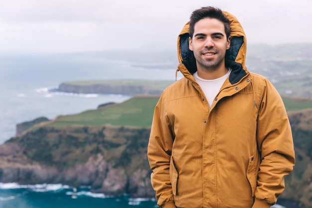 Man traveler standing overlooking a mountain lake vacation conc