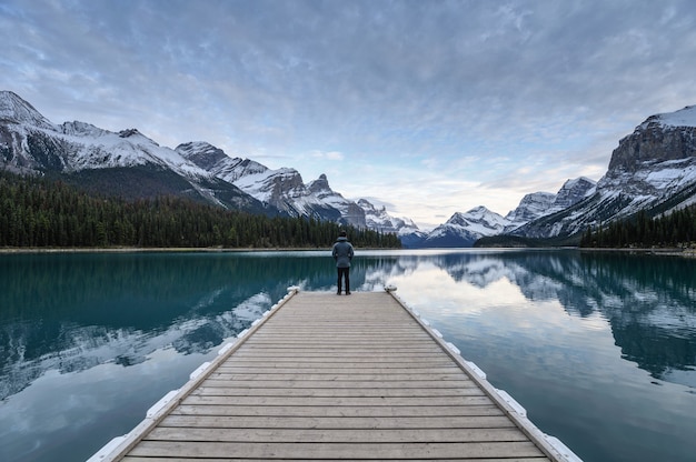 Man traveler standing on a pier in front of Lake