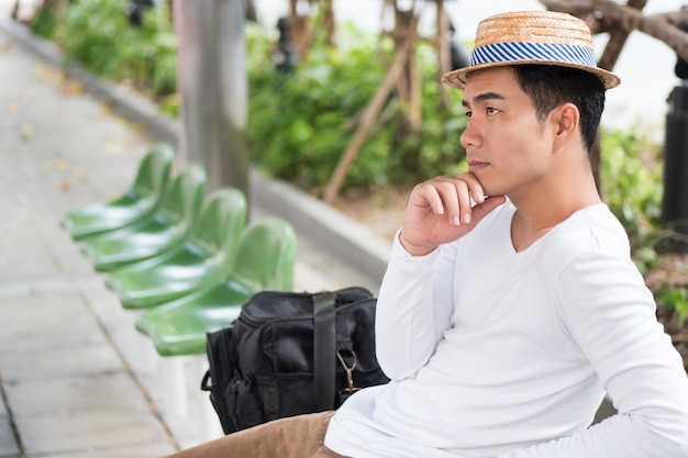 Man traveler thinking, planning at bus stop