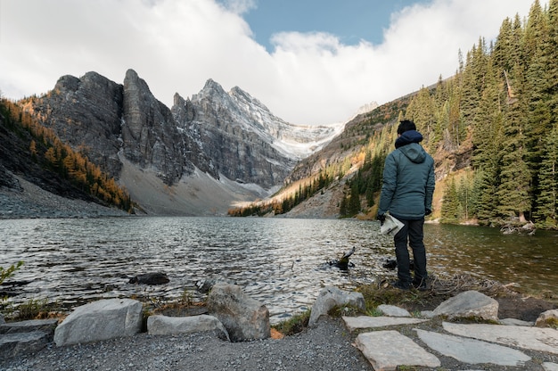 Viaggiatore dell'uomo con la mappa che sta sul lago agnes al parco nazionale di banff