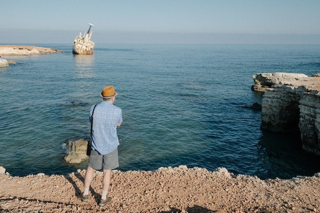 キプロスの海の近くを旅する男。男のライフスタイルコンセプト夏休みアウトドア。背景の背面図の美しい自然の風景