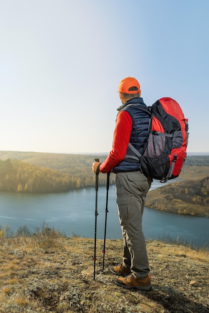 Man traveling with backpack hiking in mountains at sunrise