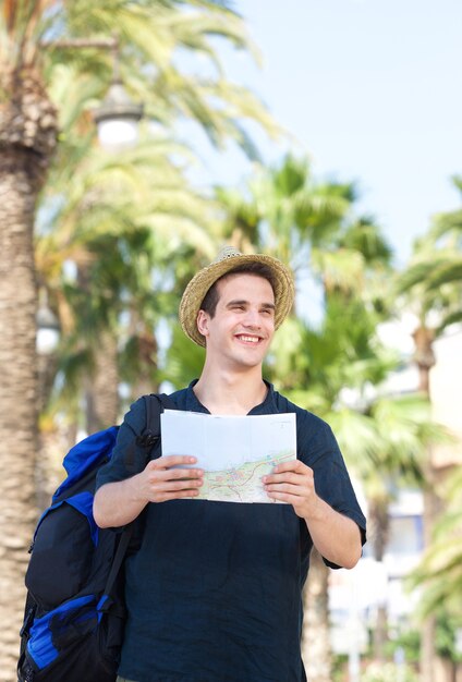 バッグと地図で旅行する男