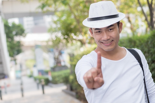 Man traveller giving number one finger gesture