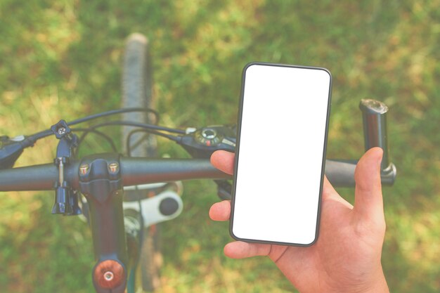 Man treinen op fiets met smartphone