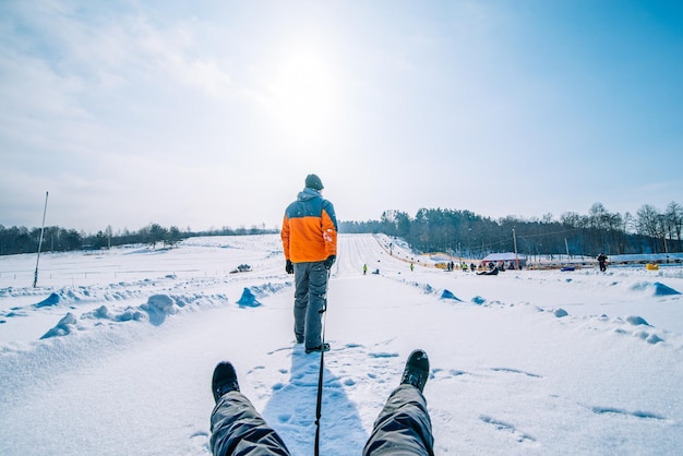 Man trekt slee met vriend winteractiviteit