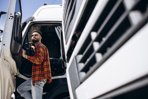 Photo man trucker happy standing by his truck