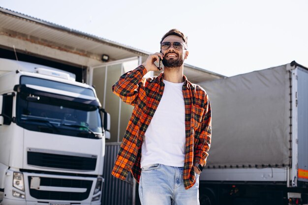 Foto man trucker praten aan de telefoon in het vrachtwagenkamp