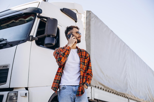 Foto uomo camionista parlando al telefono dal suo camion bianco