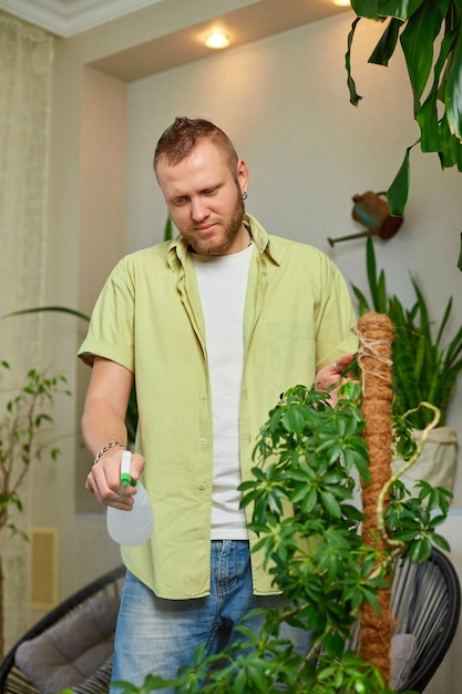 Man tuinman sproeit schefflera pot water water thuis