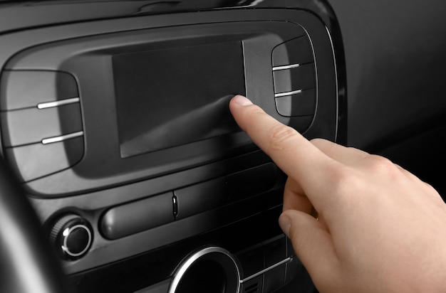 Man tuning radio in car