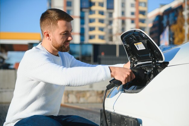 車の充電をオンにする男