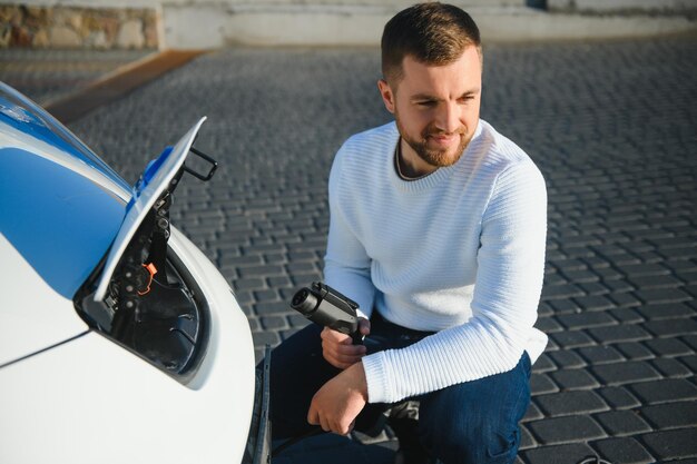 車の充電をオンにする男