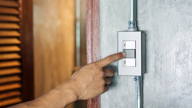 Man turning on or off on a light switch.