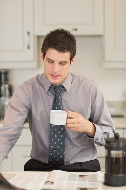 Человек, переворачивающий страницу во время питья кофе