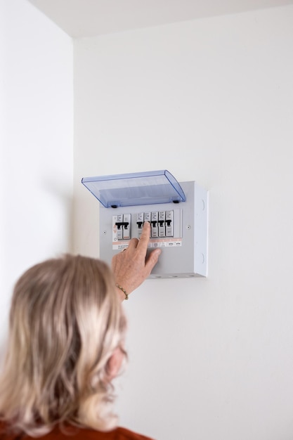 A man turns on a switch on an electrical panel in a room Distributor Electricity