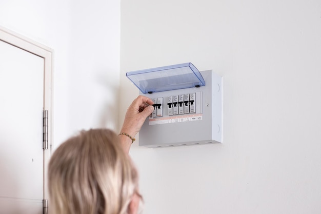 A man turns on a switch on an electrical panel in a room Distributor Electricity