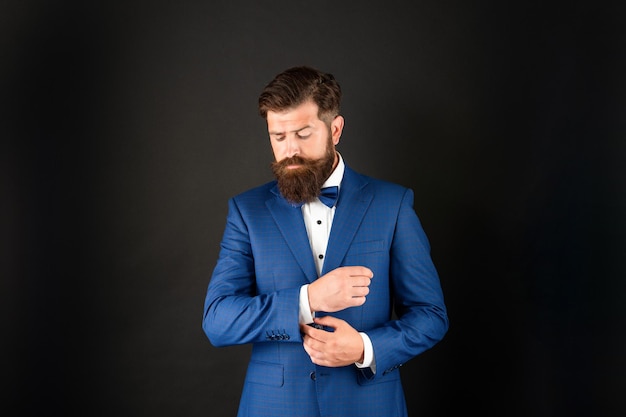 Man in tuxedo bow tie. butler in formalwear on black\
background. male formal fashion.