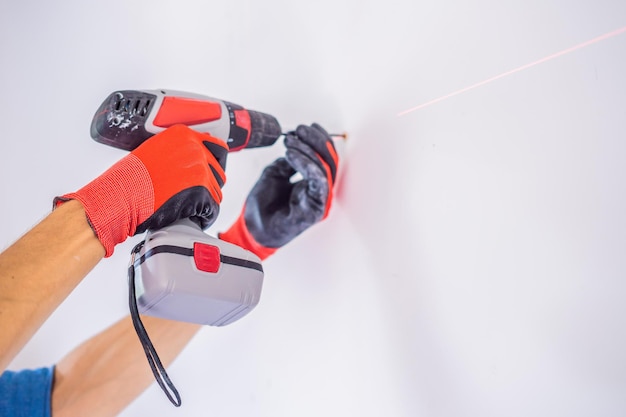 Man twists a screw into the wall