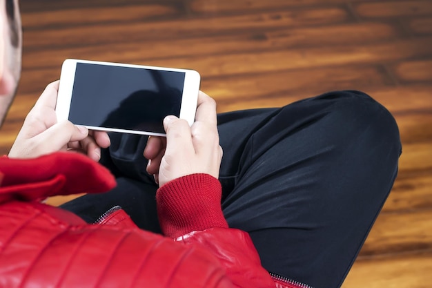 Man two hands holding smartphone with blank screen on colored background