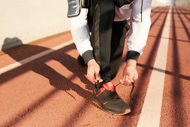 Man tying sneaker shoelace