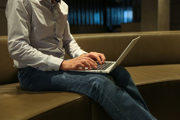 man typen op laptop in het hotel close-up