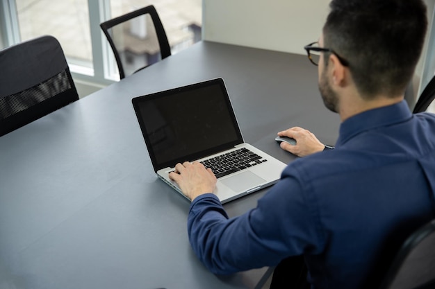 a man typing on his notebook at his office desk