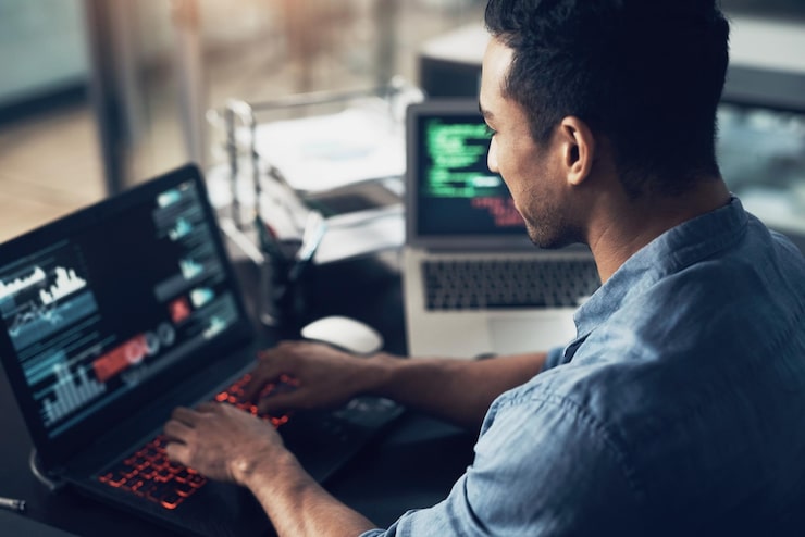 Photo man typing and programmer on laptop in office workplace for data analysis or statistics it computer and male coder engineer or person programming coding and software development for information