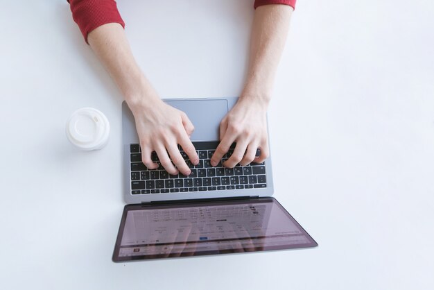 Man typing the text on the laptop keyboard