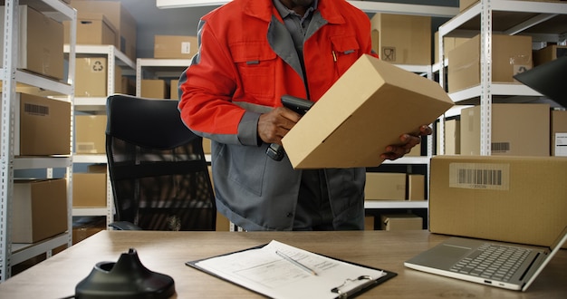 Photo man in uniform scanning a parcel